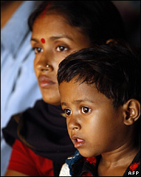 O portador do vírus HIV Rimi Sanda (dir.) e sua mãe assistem a apresentação no Dia Mundial de Luta contra Aids
