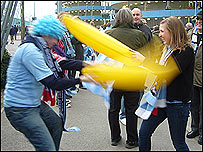 Manchester City fans play fighting with inflatable bananas outside the City of Manchester Stadium before the UEFA Cup quarter final against Hamburg