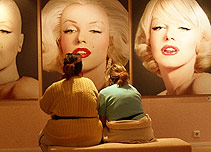 Two women looking at pictures of Marilyn Monroe