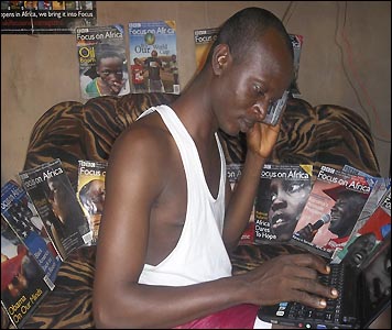 A loyal reader of BBC Focus on Africa magazine tunes in to the World Service while checking out news reports on his laptop