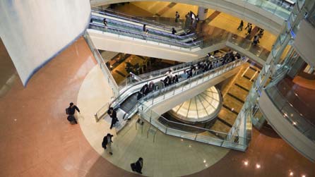 A Japanese city street at night. Young people walking and laughing.