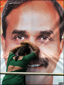 A woman grieving in front of a poster of YSR Reddy