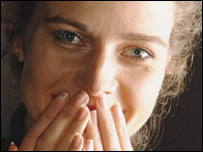 An embarrassed woman with hands over her mouth