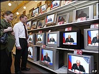 Aparelhos de TV com imagens de Vladimir Putin, presidente da Rússia