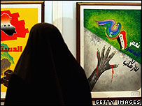 يک زن عراقی به پوسترهای انتخابات عراق نگاه می کند