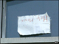 Yardım çağrıları içeren bir mesajın asılı olduğu bir ev