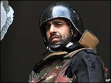 Một lính đặc nhiệm Ấn Độ nhìn từ cửa sổ khách sạn Taj Mahal Palace hôm thứ Bảy, 29/11