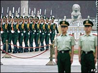 Čínští policisté a denní rituál vztyčování vlajky na náměstí Nebeského klidu