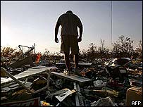 يک ساکن ميسی سيپی در ميان ويرانه های خانه اش مشغول جستجوست