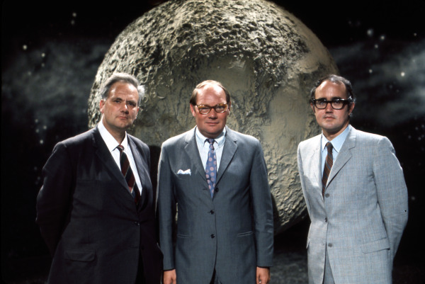 Presenters of the BBC's coverage of the first moon landings (from left to right): Patrick Moore, Cliff Michelmore and James Burke, standing in front of a large photograph of the moon