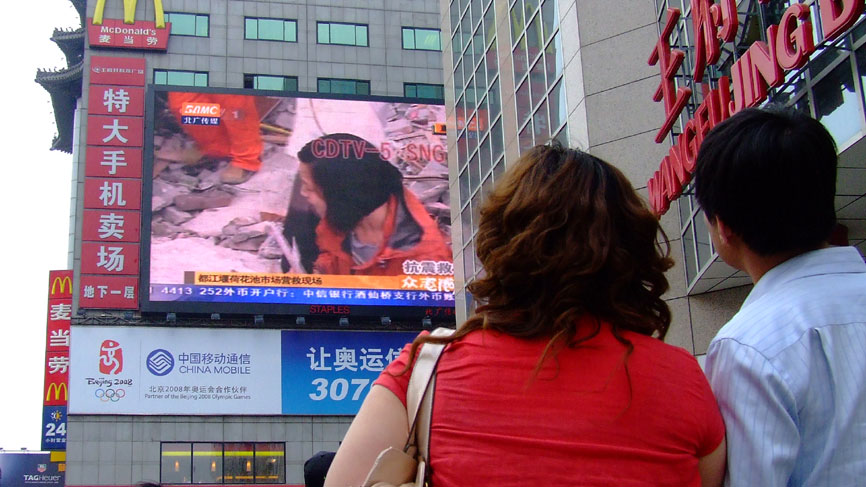 People in Beijing watching a giant TV showing the earthquake in Sichuan province, May 12th 2008.