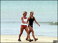 Duas turistas ocidentais passeiam na praia de Phuket