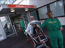 Paramedics pushing patient on trolley into hospital