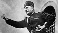Italian leader Benito Mussolini assumes a characteristic pose as he speaks to an audience in Italy in 1934