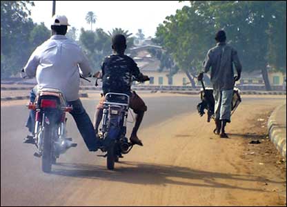 With sufficient fuel for only one of their motorcycles, a younger rider receives a helpful push from his friend