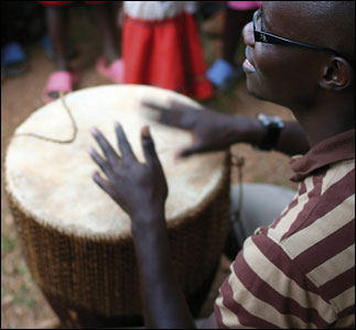 A drummer entertains and distracts children waiting to be de-wormed at Jjokerlara village