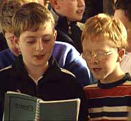 Boys singing from a hymn book