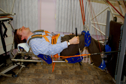 Richard Hollingham exercising simulating no gravity strapped into a contraption and lying horizontally.