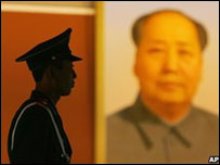 Policial em frente ao retrato de Mao Tsé-Tung, em Pequim