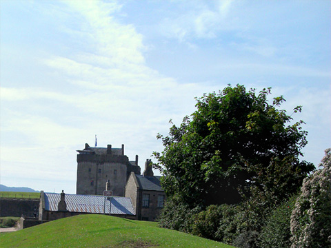 Colour view along grassy embankment to Broughty Castle, with beach to the left of frame.