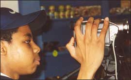Pupil with video camera making film 