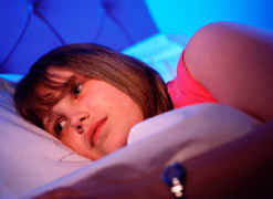 A girl trying to sleep in bed