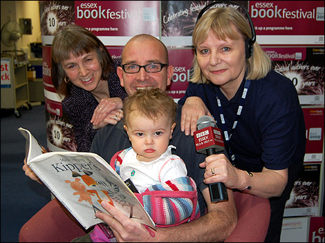 Adults and young child with a book