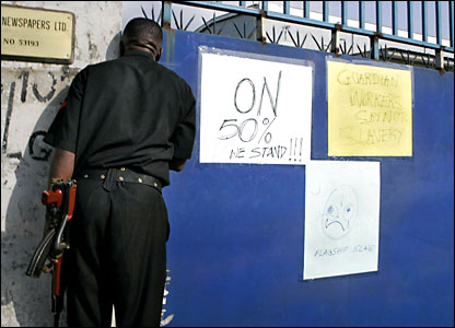 A policeman peers through the gates of