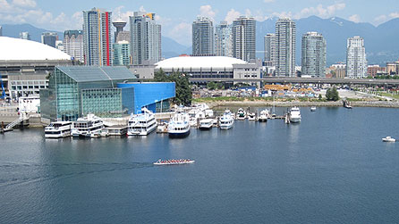 View of east-central Vancouver, with coastal range mountains in background, and two Olympic venues in middle. BC Place on the left will host the Opening and Closing ceremonies. GM Place (or Canada Hockey place) in the centre, will host the hockey events during the Vancouver 2010 Winter Olympics (officially known as the XXI Olympic Winter Games). copyright Arlene Gregorius/BBC