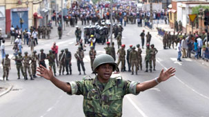 A security guard attempts to hold back supporters of Madagascar's President Marc Ravalomanana as they gather near the main square of the Madagascan capital on February 14, 2009.