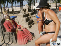 Banhistas vêem escultura de areia com a imagem de João Paulo 2º em Copacabana