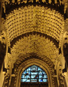 Illuminated vaulted ceiling covered with hundreds of flowers, at the top of the picture, and stars, lower down