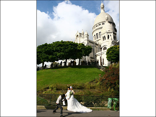 一對中國年輕夫婦在蒙瑪特的聖心堂下拍攝婚紗照。