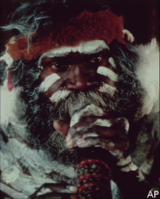 An aborigine in ceremonial colours with didgeridoo
