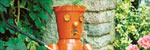 A model of a man made of plant pots sitting in a garden