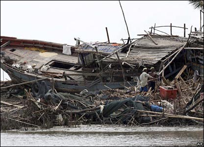 Villagers reoair their houses near a wrecked ship in Pyapon in the Irrawadday delta