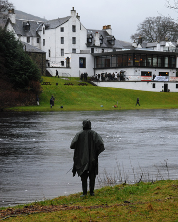 lone fisherman with hotel in the background
