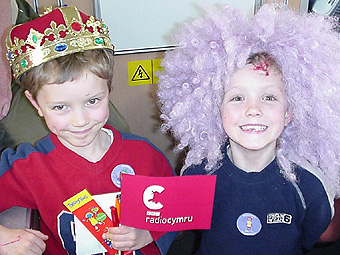 Dau fachgen bach yn gwisgo wigs.