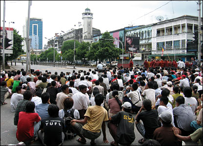 Civilians and monks in saying prayers in the street.