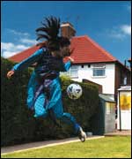 Girl playing with football in garden
