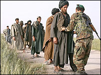 سرباز افغان، مظنونان طالبان را بازرسی می کند (عکس از آرشيو)