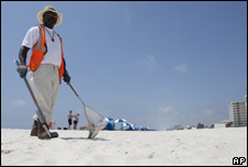 An oil spill clean up worker searches for tar balls on the beach in Perdido Key, Florida in April 2011
