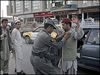 سرباز افغان در حال بازرسی مسافران در قندهار