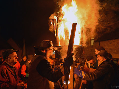 Men carrying a burning barrel