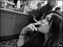 Mulher fuma em café parisiense