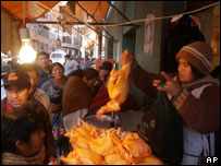 Mulher vende galinha em mercado de rua de La Paz