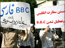 Protestors in Iran hold up placards stating (l-r) "BBC Persian is against the government of the people" and "Close down the British Embassy and close down the BBC"