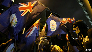 帶著面具的反政府示威者手持港英時代旗幟遊行（1/1/2013）