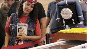 Partidária de Chávez passa ao lado de caixão (foto: AFP)