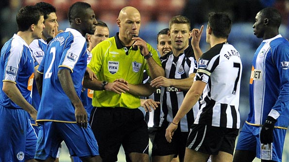 Players from Wigan and Newcastle surround referee Howard Webb. Photo: Getty Images
